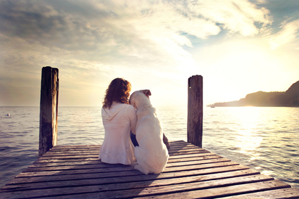 woman embracing sweetly his dog while looking the view